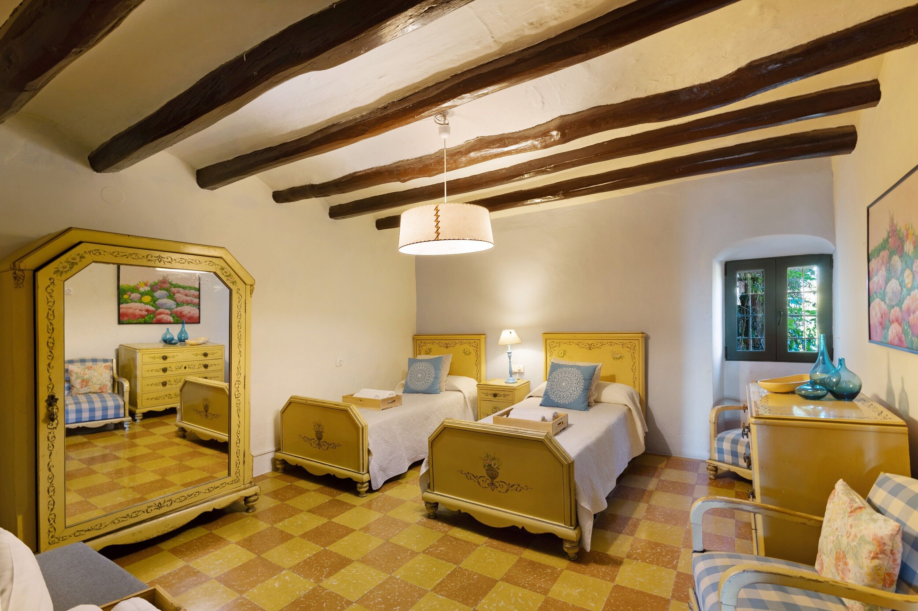 A room with two beds, a mirror, a dresser, and a window with a view.