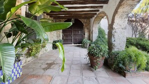 A courtyard with stone flooring, wooden beams, and potted plants. - Country House 'Casa Espigol' with Mountain Views, Private Pool and Wi-Fi (El Bruc)