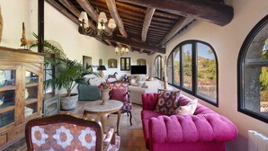 A spacious living area with a high ceiling, large windows, and a cozy seating arrangement. - Country House 'Casa Espigol' with Mountain Views, Private Pool and Wi-Fi (El Bruc)