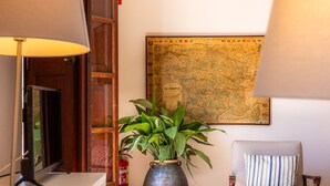 A room with a map on the wall, a plant in a pot, a chair, and a television. - Apartment 'Can Claret' with Balcony, Wi-Fi and Air Conditioning (Felanitx)