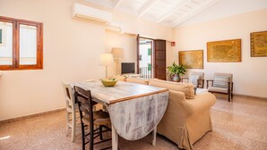 A spacious living area with a dining table, sofa, and a TV. - Apartment 'Can Claret' with Balcony, Wi-Fi and Air Conditioning (Felanitx)