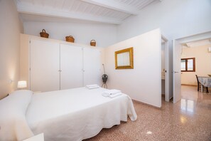 Ein Schlafzimmer mit Bett, Kleiderschrank, Spiegel und Essecke.