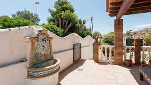 A rooftop terrace with a decorative fountain, potted plants, and a view of surrounding greenery. - Casa del Golf – 15-min walk to the beach, mountain view, private pool, Wi-Fi (Málaga)