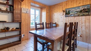 Interior de madera con una mesa de comedor, sillas, un cuadro y un cartel que indica la disponibilidad de WIFI.