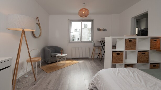 Una camera da letto moderna con un letto, una lampada da terra, una sedia, un tavolino e mobili a incasso.