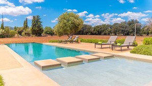 A swimming pool with lounge chairs and a tree in the background. - SON CATXO - Villa with private pool in Búger. Free Wifi. (Búger)
