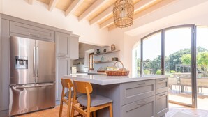 A modern kitchen with a large island, stainless steel appliances, and a view to the outdoors. - SON CATXO - Villa with private pool in Búger. Free Wifi. (Búger)