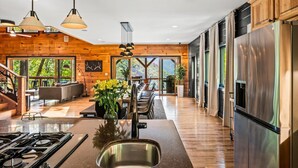 A modern kitchen with a central island, stainless steel appliances, and a dining area with a view of the outdoors.