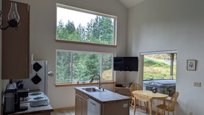 Una cocina moderna con lavavajillas, estufa y comedor con mesa y sillas.