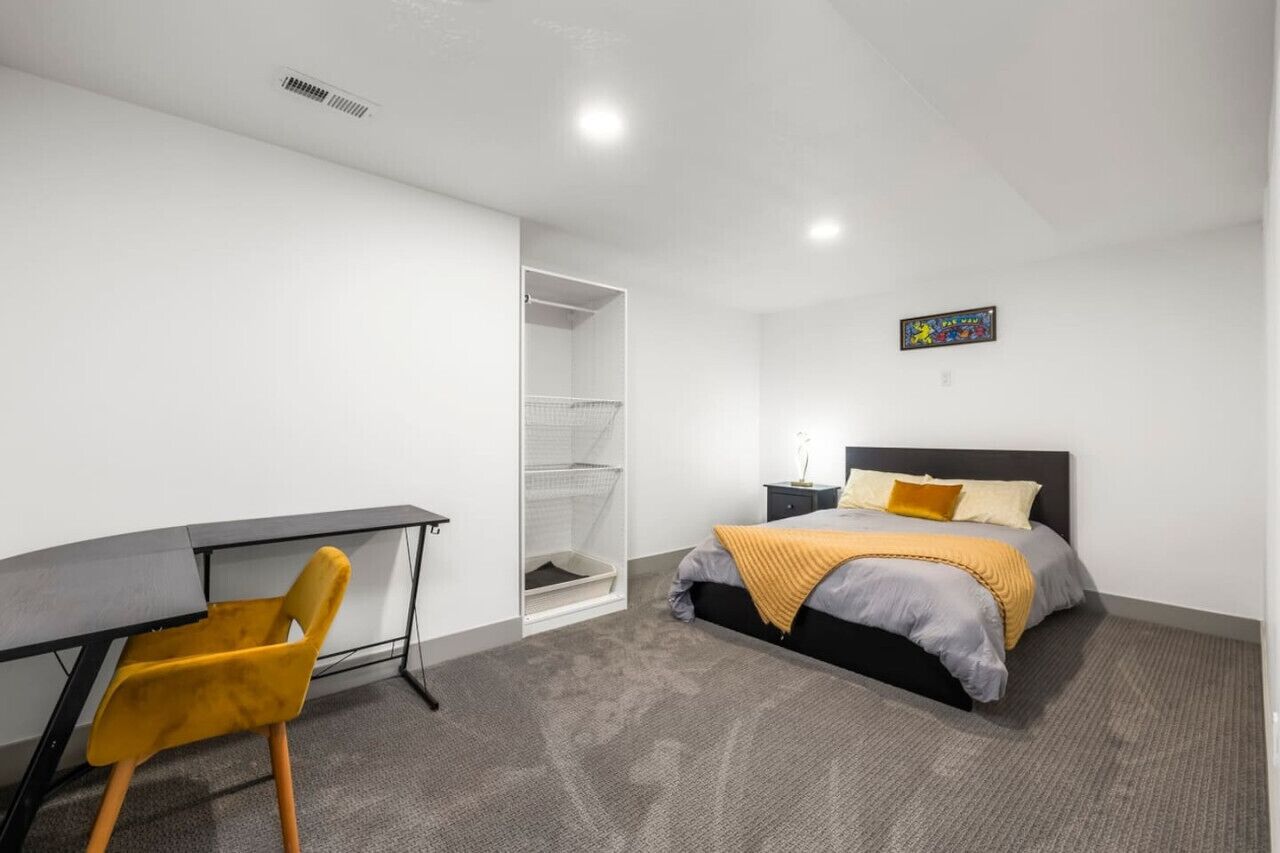 Une chambre à coucher moderne avec un lit, un bureau et une chaise.
