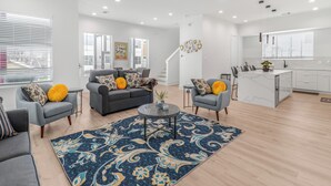 A modern living room with grey sofas, a coffee table, and a patterned rug.