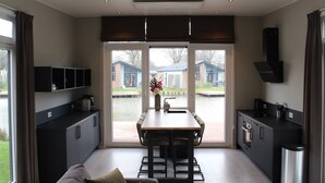 Una cocina moderna con comedor, ventanas amplias y vista al jardín trasero.