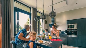 Una cocina moderna con mesa, sillas y un ventanal grande.