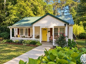 A single-story house with a green roof, a porch with white railings, and a yellow door. - Pet-Friendly Downtown Cottage: Dogs Stay FREE- Near Wedding Venues (Bremen)