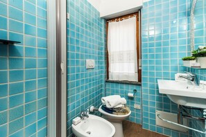 A bathroom with blue tiles, a white sink, and a toilet. - Casa La Boa, Stintino, Italy (Stintino)