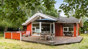 A house with a deck, a dining table, and chairs. - 2 bedroom gorgeous home in Slagelse (Slagelse)