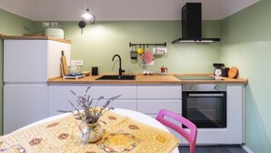 Uma cozinha compacta com pia, fogão e área de refeições com mesa e cadeiras.