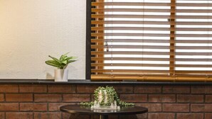 A small round table with two black stools, a potted plant on the wall, and a window with blinds. - 1 bed 1 bath | Quiet neighborhood (Sioux Falls)