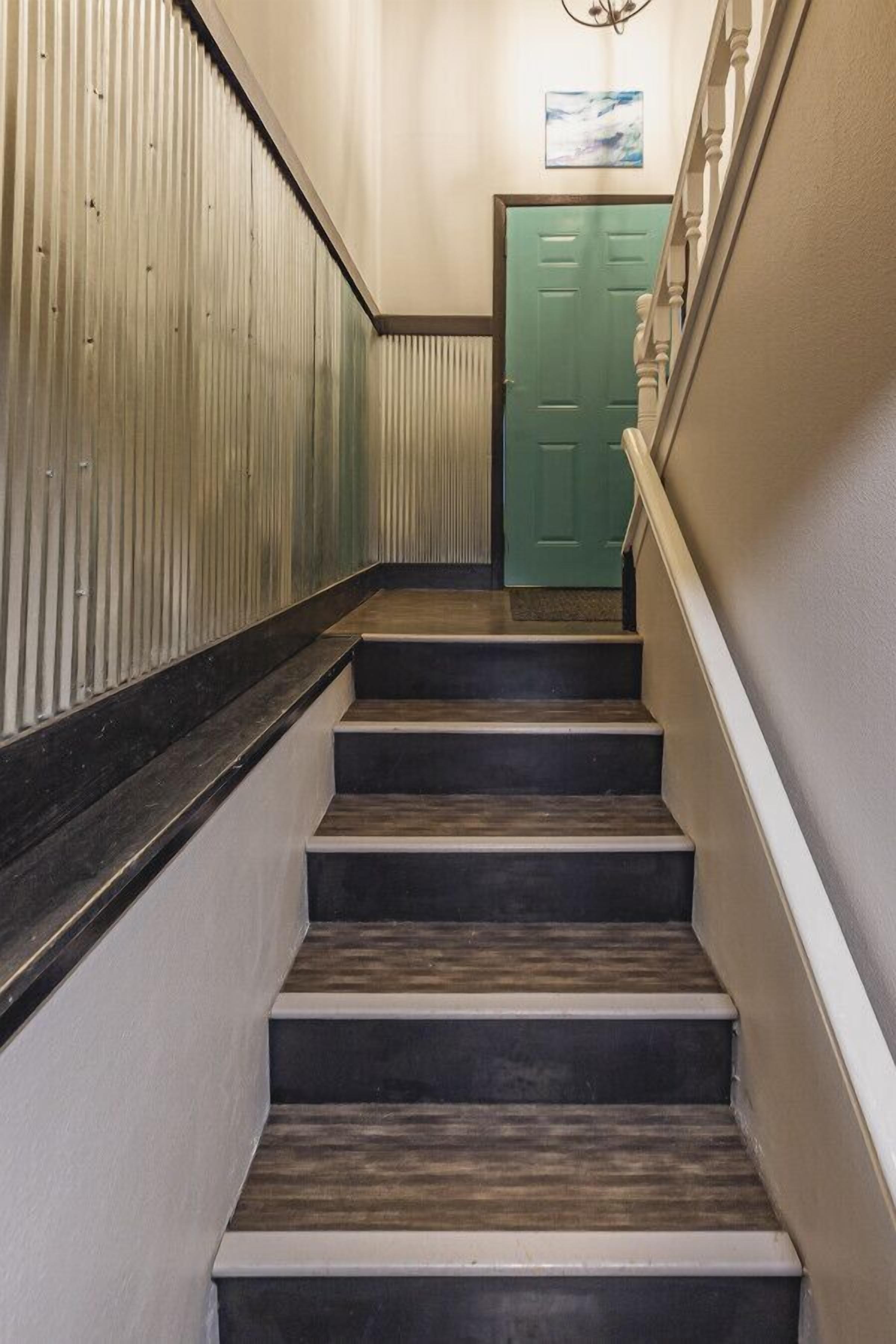 A staircase with dark steps and a green door at the top.