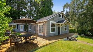 Een tweelaags huis met een terras, een overdekte patio en een voortuin.