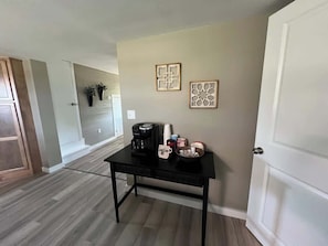 Une pièce avec une table noire, une machine à café et des objets décoratifs accrochés au mur.