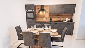 A modern kitchen with dark cabinets, a built-in oven, and a wooden countertop. - Sunshine view 3 by Interhome (Reifnitz)