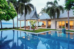 Ein modernes Resort mit großzügigem Infinity-Pool, einem Essbereich im Freien und Blick auf den Ozean.