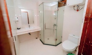 A bathroom with a glass-enclosed shower, a sink, and a toilet. - Hoa Hong 1 Hotel SS - by Bay Luxury (Sam Son)