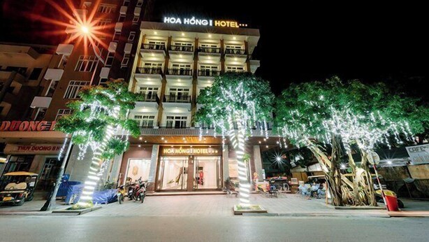 Un hotel con un cartello ben visibile, diversi piani e un ingresso luminoso.