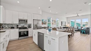 A modern kitchen with white cabinets, stainless steel appliances, and a central island.