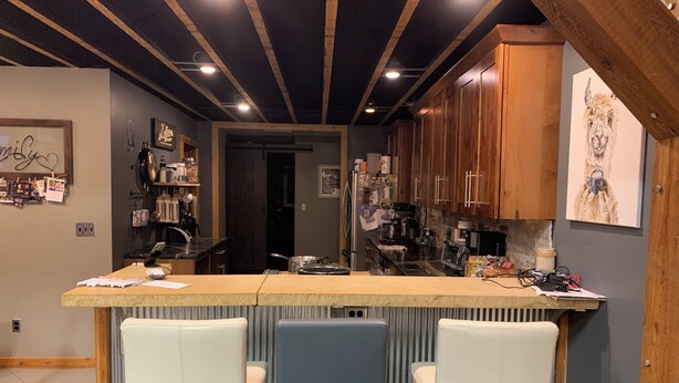 A kitchen with a bar area, wooden cabinets, and a refrigerator. - Outdoor Oasis and Pickleball Paradise: Fishing, Paddle-boarding, Swimming (Augusta)