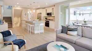 En modern lägenhet med kök, matplats och vardagsrum.