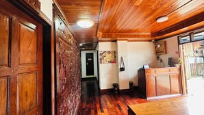 A wooden interior with a polished floor, a reception desk, and a door marked "A2". - Silikhane Guest House (Luang Prabang)