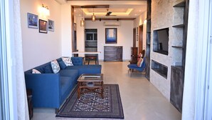 Ein modernes Wohnzimmer mit einem blauen Sofa, einem Couchtisch und einem Kamin.