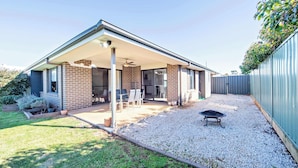 A house with a covered patio, a barbecue grill, and a gravel driveway. - Magnolia Entertainer. Firepit & Pets. Dubbo Family (Dubbo)