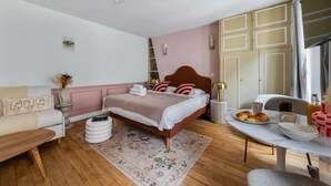 Una camera da letto con un letto, un comodino e un'area pranzo con tavolo e sedie.