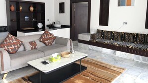 Una sala de estar moderna con un sofá gris, una mesa de centro y un conjunto de sofás estampados.
