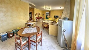 A compact living space with a dining area, kitchen, and a small seating area.