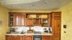 A kitchen with wooden cabinets, a sink, a stove, a microwave, and a dishwasher.