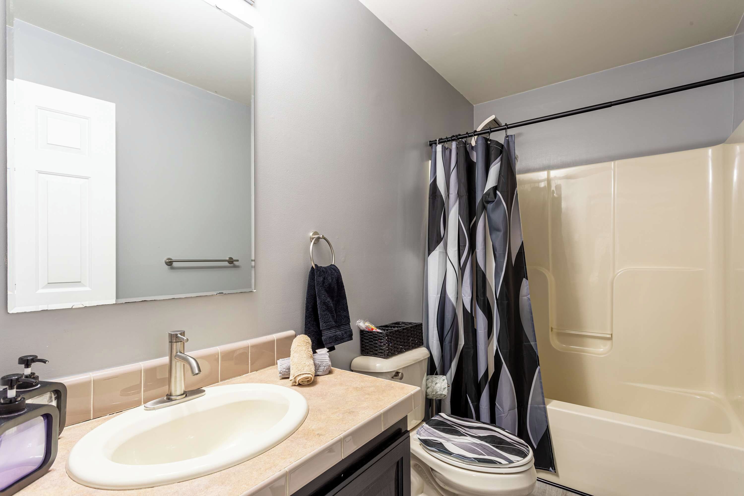 Ein Badezimmer mit Waschbecken, Spiegel, Toilette und Dusche.