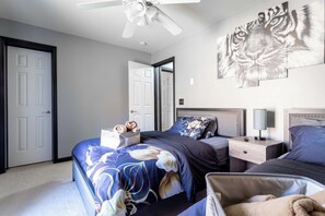 A bedroom with a bed, nightstands, a ceiling fan, a wall-mounted tiger artwork, and a door. - Hot Tub | Game Room | Fenced Yard | Dog Friendly (Albrightsville)