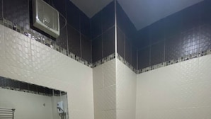 A bathroom with a sink, mirror, toilet, and a trash bin. - Happyroom Airport Chiangrai (Chiang Rai)