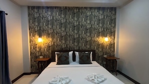A modern hotel room with a large bed, two bedside tables, a patterned wall, and two wall-mounted lights. - Happyroom Airport Chiangrai (Chiang Rai)