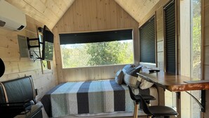 A cozy cabin-style room with a loft bed, a desk, and a chair. - Ranch style living with incredible views! (Cambria)