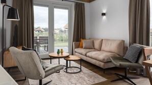 Una sala de estar con sofá, sillón, mesa de centro y lámpara.