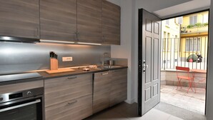 A modern kitchen with wooden cabinets, a stainless steel oven, and a sink. - Lovely apartment for 4 people with A/C, WIFI, TV and patio (Milan)