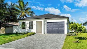 A modern two-story house with a garage, paved driveway, and well-maintained lawn.