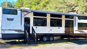 Een witte camper met een schuifdeur en een klein terras.