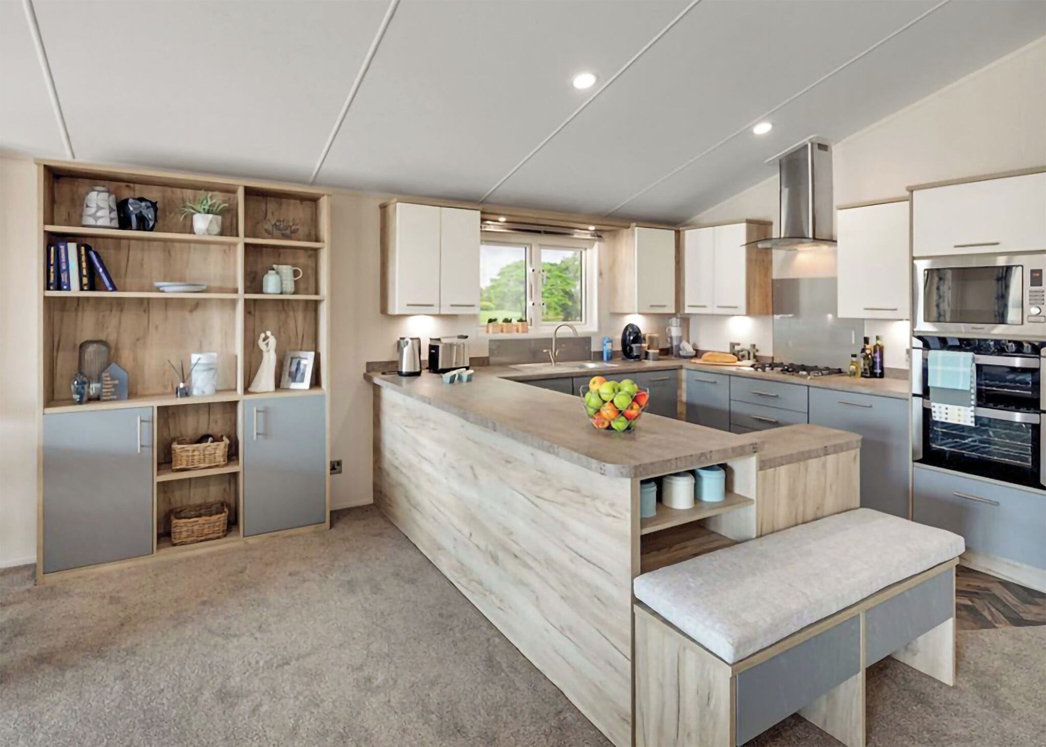 A modern kitchen with a marble countertop, built-in appliances, and a wooden bench.