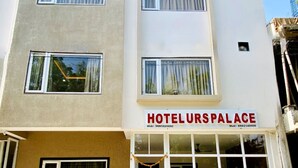 Un hotel chiamato HOTEL URSPALACE con un pavimento a scacchi di fronte.